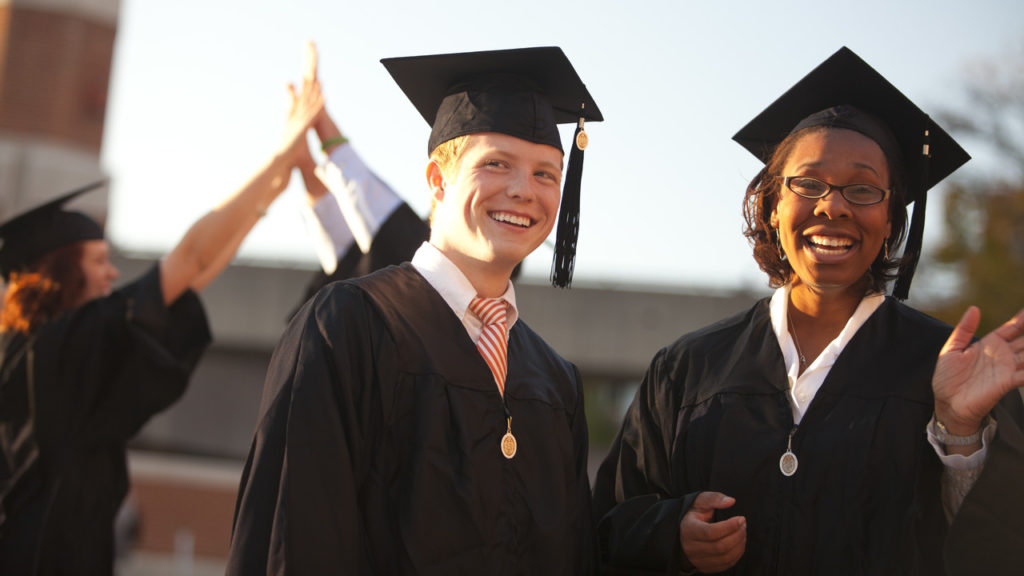 Two students dressed in their graduation attire.