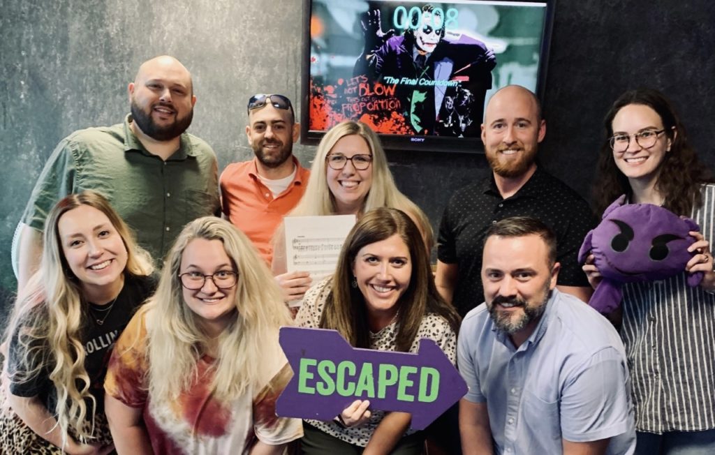 Student Conduct team posing at an Escape Room after they escaped with 8 seconds left on the clock.